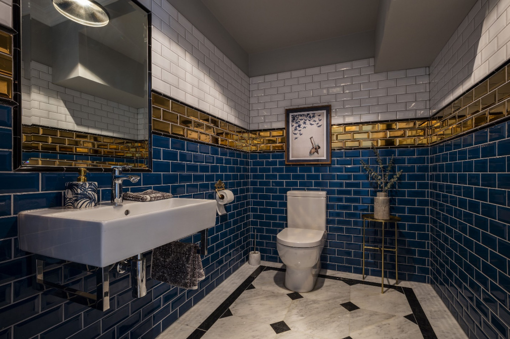 Ванная комната с черной, синей, золотой и белой плиткой