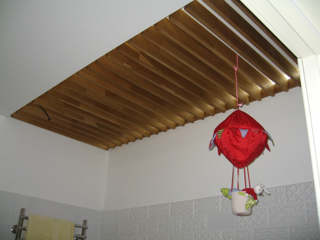 Часть потолка в ванной с отделкой широкими декоративными баффелями