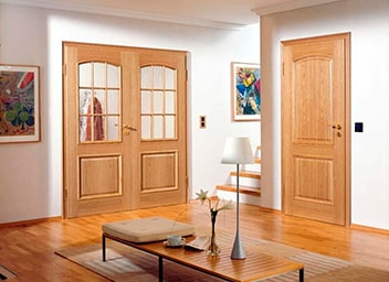Неокрашенные двери из массива сосны отлично сочетаются с натуральными напольными покрытиями 