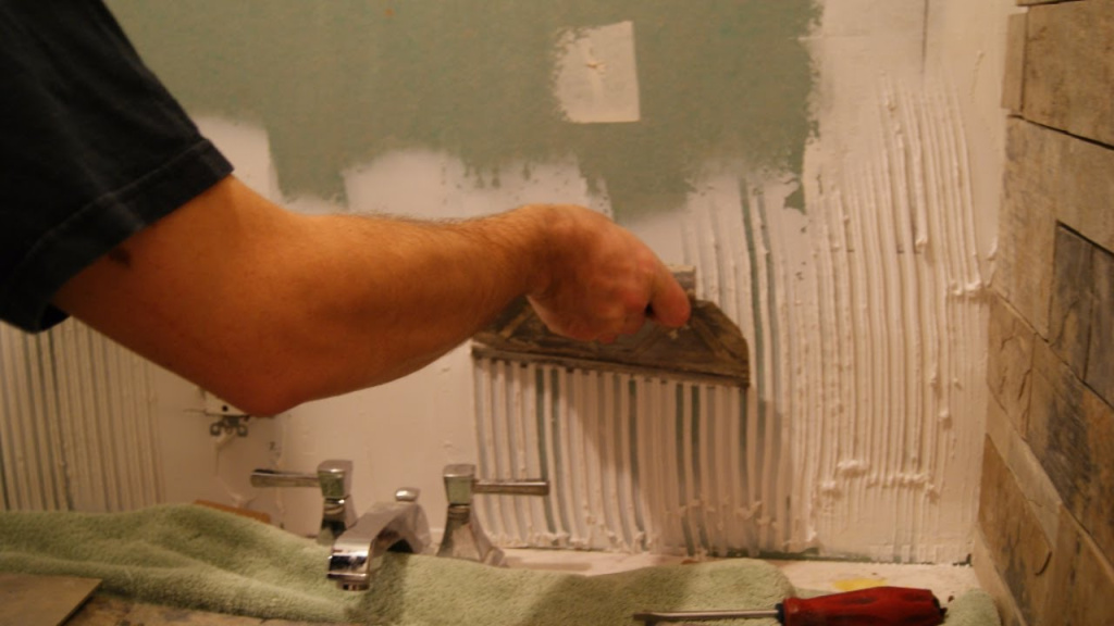 Выравнивание поверхности стены ванной шпатлевкой