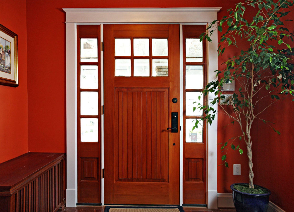 Деревянная дверь красного оттенка с остеклением в интерьере частного дома