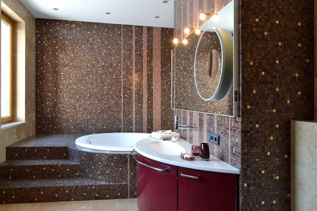 Мозаика на стене отлично сочетается с каменной плиткой на полу в ванной комнате